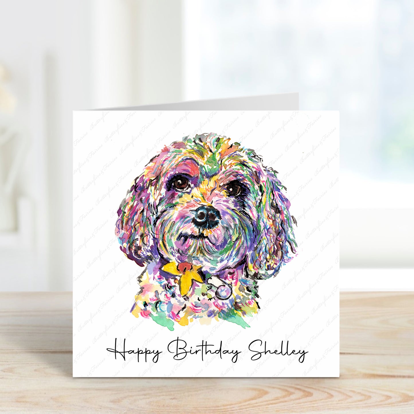 A square card with a colourful Cavapoo and a white background