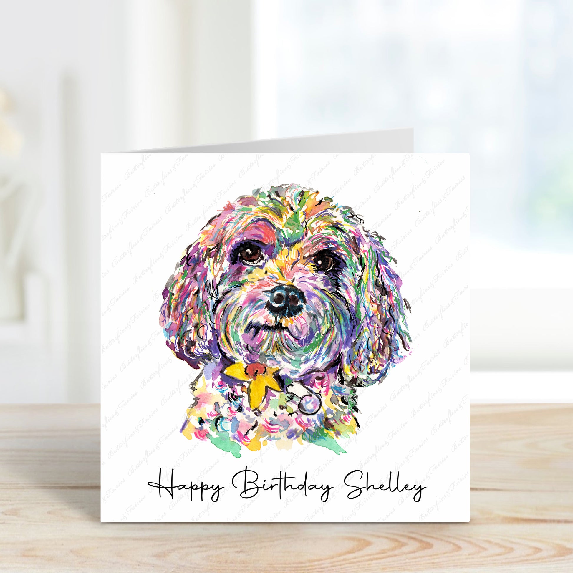 A square card with a colourful Cavapoo and a white background