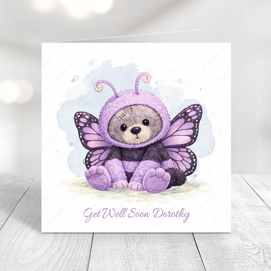 Card with a teddy bear in a purple butterfly costume on a light background