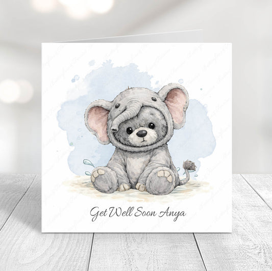 Card with a cute teddy in an elephant costume  illustration and 'Get Well Soon' text on a light background.
