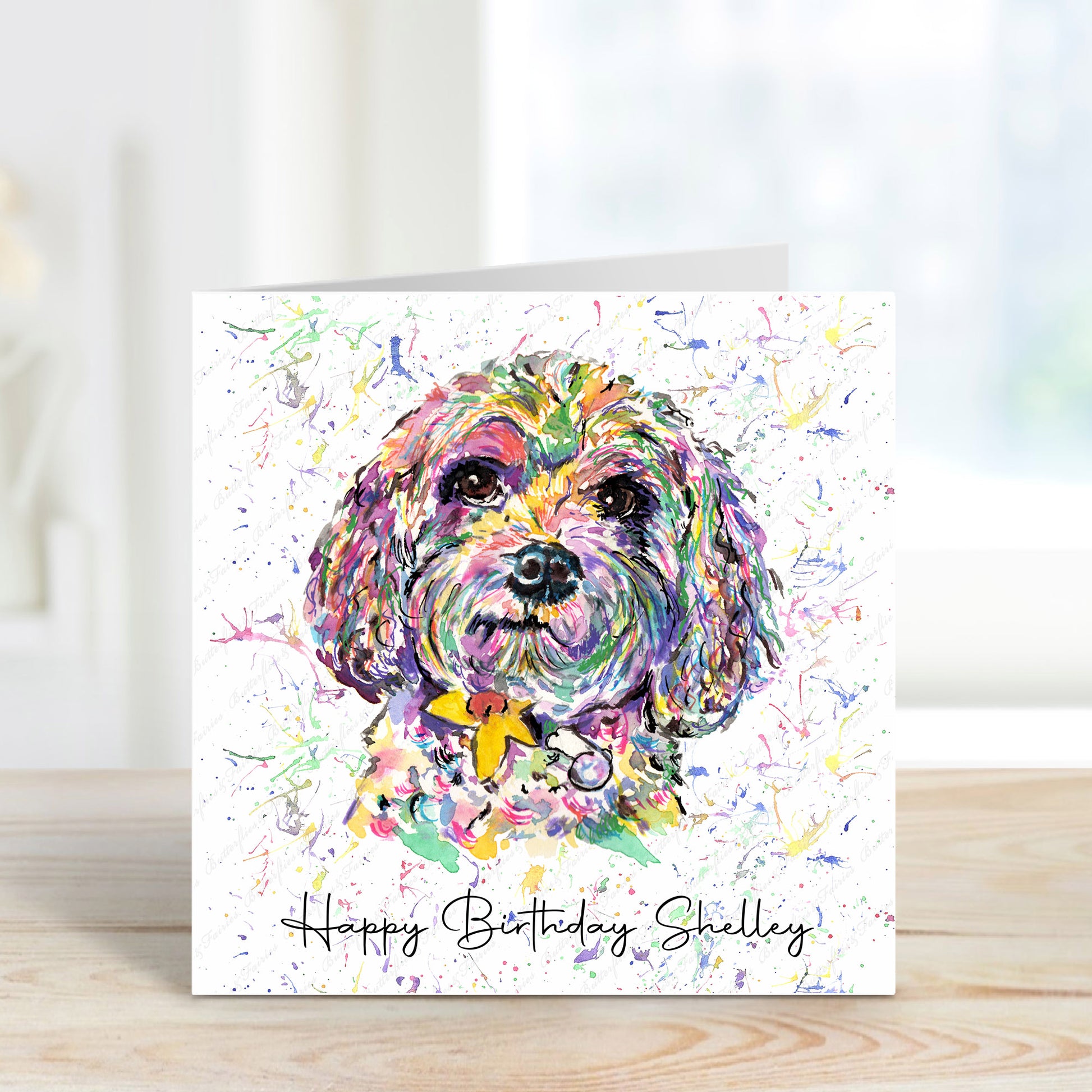 A square card with a colourful Cavapoo and a white background